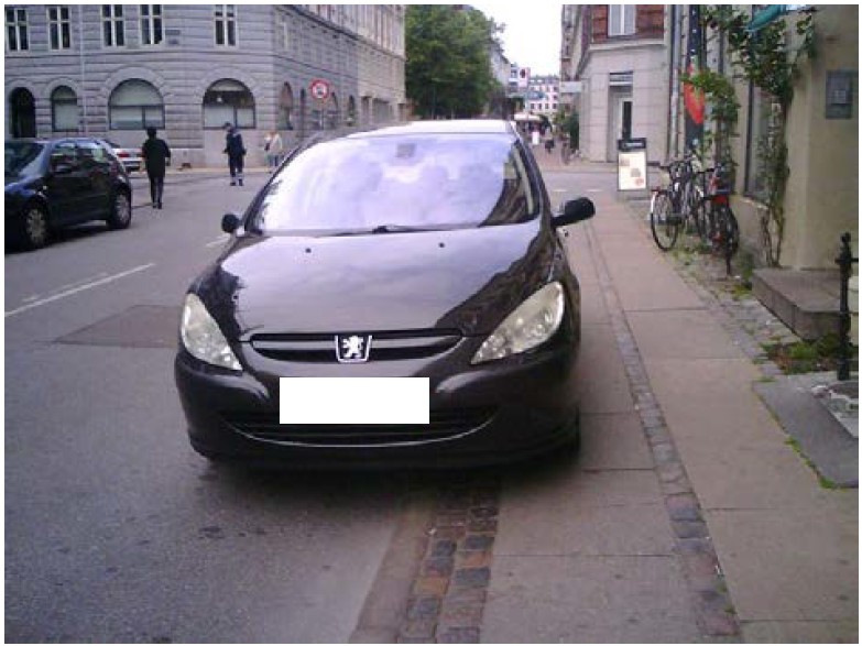 Bil der holder parkeret på et fortov