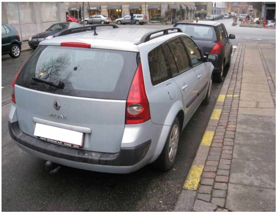 Ulovlig parkeret bil ved brudt gul kantlinje