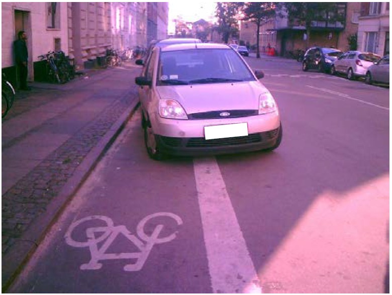 Bil der holder parkeret på en cykelsti