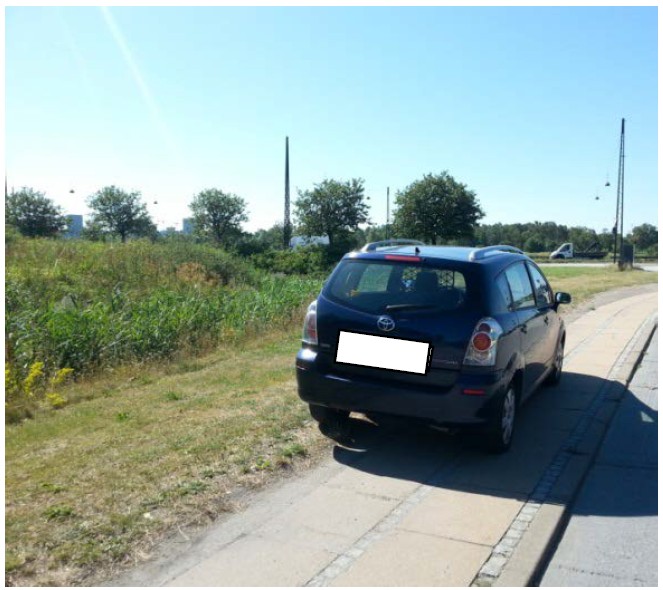 Bil der holder parkeret på et fortov