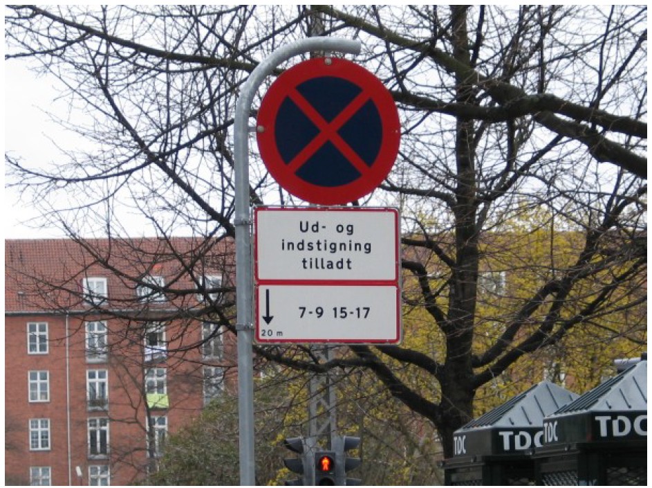 Skilt der viser betinget standsningsforbud, hvor kun ud- og indstigning er tilladt.